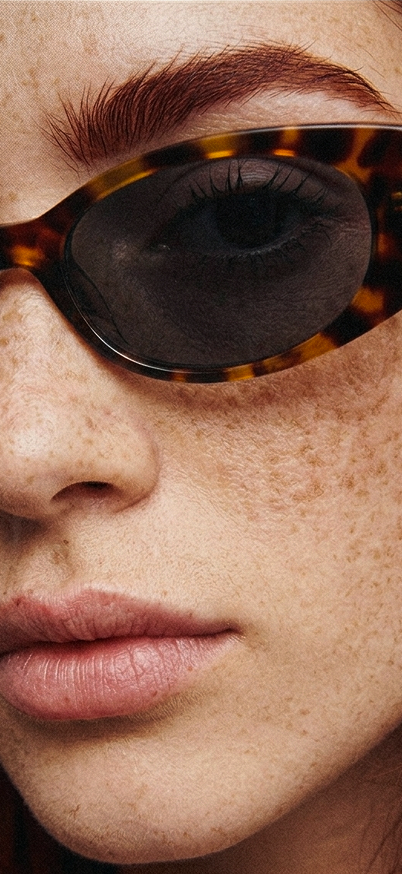 Close-up of a person wearing tortoiseshell sunglasses with a focus on the eye area.
