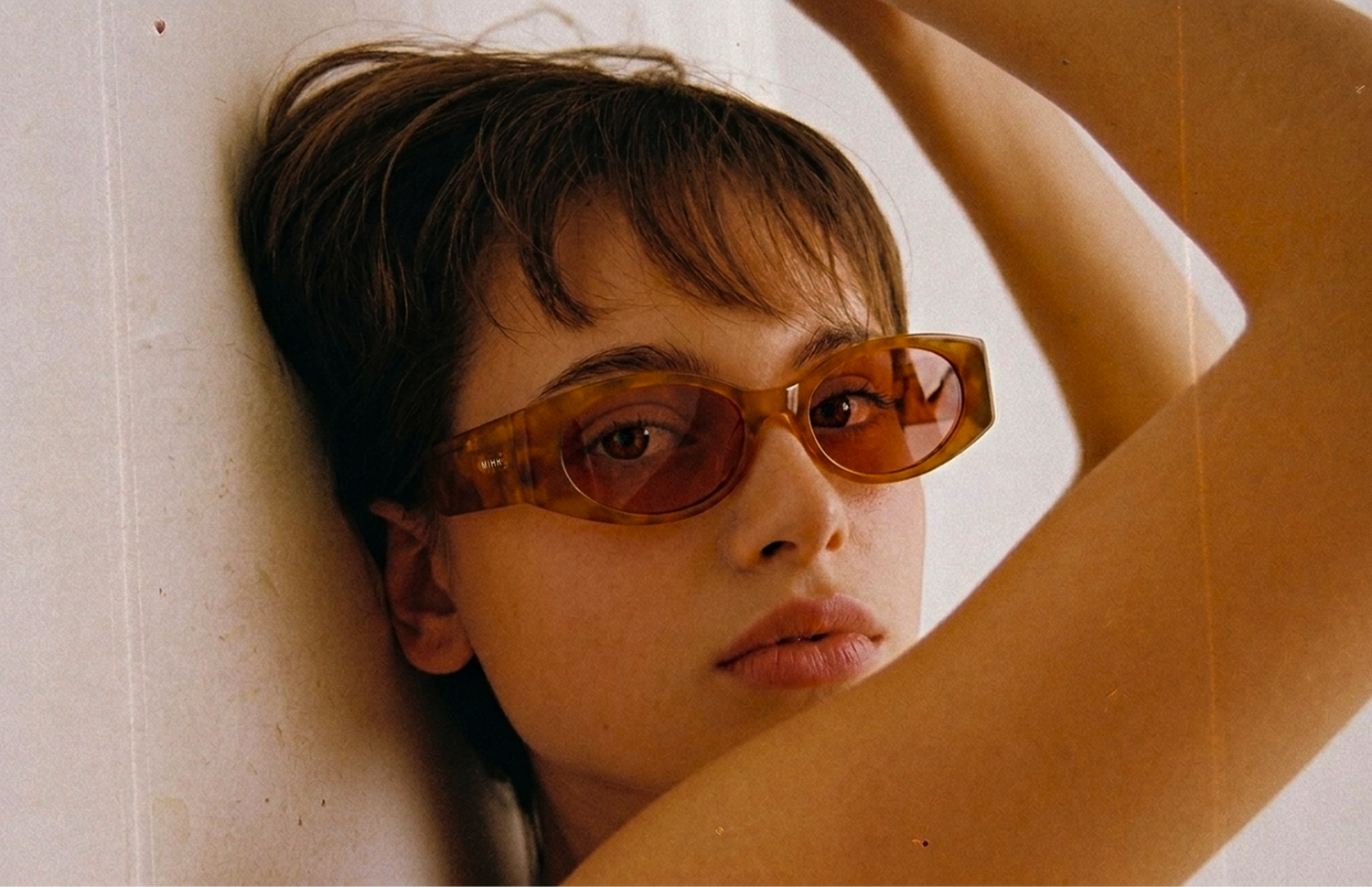 Person wearing sunglasses with a neutral background